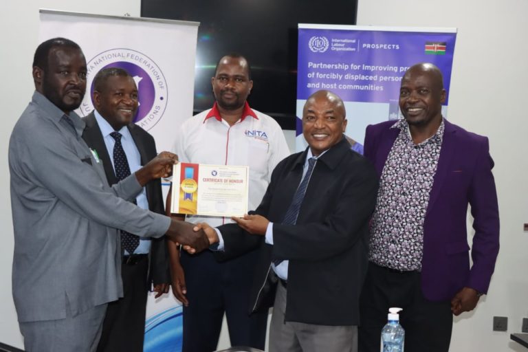 CEO,KNFJA Richard Muteti 2nd R receiving a certificate of Honour from from the KNFJA Sec General Eng Charles Kalomba( L) for his 15 years of service to the Association. Also present were CEO TVET CDACC Dr. Lawrence Guantai 2nd L, Peter Njiru from NITA(C) & Stanley Maindi, KNQA (R).This was during the ongoing acapacity Building workshop at Eseriani Hotel Naivasha.
